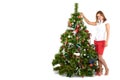 Beautiful smiling woman in red, decorating christmas tree, on white