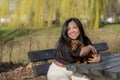 Beautiful smiling woman sitting on a bench hugging a puppy Royalty Free Stock Photo