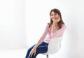 Beautiful smiling woman sitting on chair with copy space Royalty Free Stock Photo