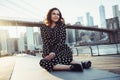 Beautiful smiling woman sitting in city park looking to the side and smiling. New York tourist travel lifestyle concept Royalty Free Stock Photo