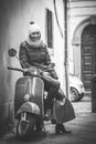 Beautiful smiling woman sitting on an old Italian motorcycle