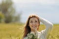 beautiful smiling woman in sunny autumn field with bunch of camomiles Royalty Free Stock Photo