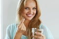 Beautiful Smiling Woman Taking Vitamin Pill. Dietary Supplement