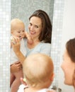 Beautiful smiling woman teaching baby how to brush teeth Royalty Free Stock Photo