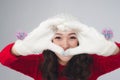 Beautiful smiling woman in warm clothing gesture heart shape