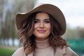 Beautiful smiling woman wearing classical hat in cold park