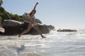 Beautiful smiling woman in white bikini leaping on the beach Royalty Free Stock Photo