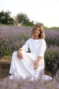 beautiful smiling woman in white dress sitting in purple