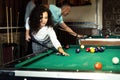 Beautiful smiling women playing billiards