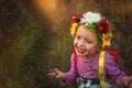 Beautiful smiling 3 years old girl in pink dress and traditional ukrainian wreath on head in sunset time. Smile on face small girl