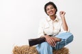 Beautiful smiling young african cowgirl sitting on a haystack