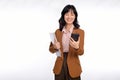 Beautiful smiling young asian businesswoman carrying laptop computer and smartphone to go while standing  over white Royalty Free Stock Photo