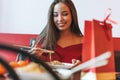 Beautiful smiling young asian woman in red clothes eating noodles with bamboo chopsticks in the chinese vietnamese restaurant