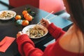 Beautiful smiling young asian woman in red clothes eating noodles with bamboo chopsticks in chinese vietnamese restaurant Royalty Free Stock Photo