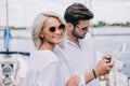 beautiful smiling young couple in sunglasses using digital tablet Royalty Free Stock Photo