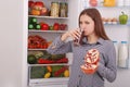 Beautiful smiling young girl holds a glass of pomegranate juice and garnet Royalty Free Stock Photo