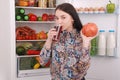 Beautiful smiling young girl holds a glass of pomegranate juice and garnet Royalty Free Stock Photo