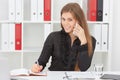 Beautiful smiling young girl make notes talking on the mobile phone sitting at office. Royalty Free Stock Photo