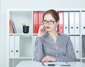 Beautiful smiling Caucasian young girl talking on the mobile phone in the office. Royalty Free Stock Photo