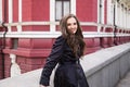 Beautiful smiling young lady in black coat posing in the city Royalty Free Stock Photo