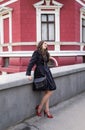 Beautiful smiling young lady in black coat posing in the city Royalty Free Stock Photo