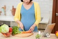 Beautiful smiling young pregnant woman preparing healthy food with lots of fruit and vegetables at home kitchen Royalty Free Stock Photo