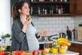 Pregnant woman preparing healthy food with lots of fruit and vegetables at home