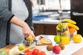 Pregnant woman preparing healthy food with lots of fruit and vegetables at home Royalty Free Stock Photo