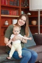 Beautiful smiling young white Caucasian woman mother holding cute adorable baby boy girl child Royalty Free Stock Photo