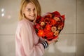 Beautiful smiling young woman with a bouquet of red flowers Royalty Free Stock Photo