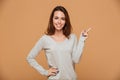 Beautiful smiling young woman in casual wear pointing with finger, looking at camera Royalty Free Stock Photo