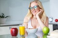 beautiful smiling young woman in eyeglasses eating breakfast Royalty Free Stock Photo