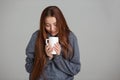 Beautiful smiling young woman feeling cold and drinking hot tea Royalty Free Stock Photo