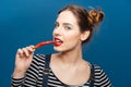 Beautiful smiling young woman holding and biting red chilli pepper Royalty Free Stock Photo