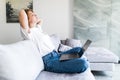 Beautiful young woman with laptop and cup of coffee on the sofa Royalty Free Stock Photo