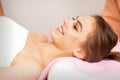 A beautiful smiling young woman is lying on a massage couch waiting for a massage in a massage room. Royalty Free Stock Photo