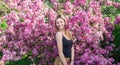 Beautiful smiling young woman near the blossoming spring tree. Portrait of pretty blond girl with long hair in pink flowers. Royalty Free Stock Photo