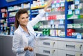 Beautiful smiling young woman pharmacist doing his work in pharmacy. Royalty Free Stock Photo