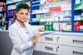 Beautiful smiling young woman pharmacist doing his work in pharmacy. Royalty Free Stock Photo