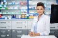 Beautiful smiling young woman pharmacist doing his work in pharmacy. Royalty Free Stock Photo