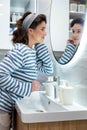 Beautiful smiling young woman posing in front of bathroom mirror enjoy reflection closeup Royalty Free Stock Photo