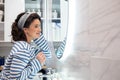 Beautiful smiling young woman posing in front of bathroom mirror enjoy reflection closeup Royalty Free Stock Photo