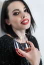 Beautiful smiling young woman with red lipstick holding up a glass of wine Royalty Free Stock Photo