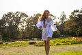 Beautiful smiling young woman runs in white clothes in a meadow with a flowers at sunset Royalty Free Stock Photo