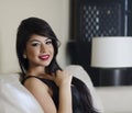 Beautiful smiling young woman sitting on sofa chair Royalty Free Stock Photo