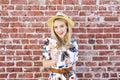 Millennial Blond Woman with an Ice Cream Cone Stands Against a Brick Wall On a Summer Day Royalty Free Stock Photo