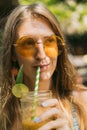 beautiful smiling young woman in sunglasses drinking tropical cocktail Royalty Free Stock Photo