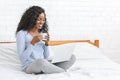 Beautiful smiling young woman watching movie on laptop, drinking tea Royalty Free Stock Photo