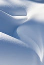 Beautiful smooth lines texture of snowdrifts play of light and shadow of a winter landscape on the background Royalty Free Stock Photo
