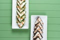 Beautiful snacks of soft cream cheese on a white plate on a green background. Cottage cheese snacks with salmon and Royalty Free Stock Photo